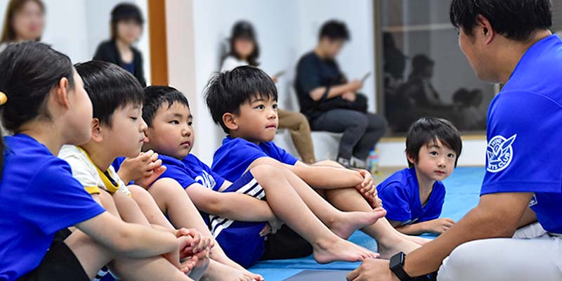 体操教室の先生の話しをちゃんと聞く幼児生徒たち